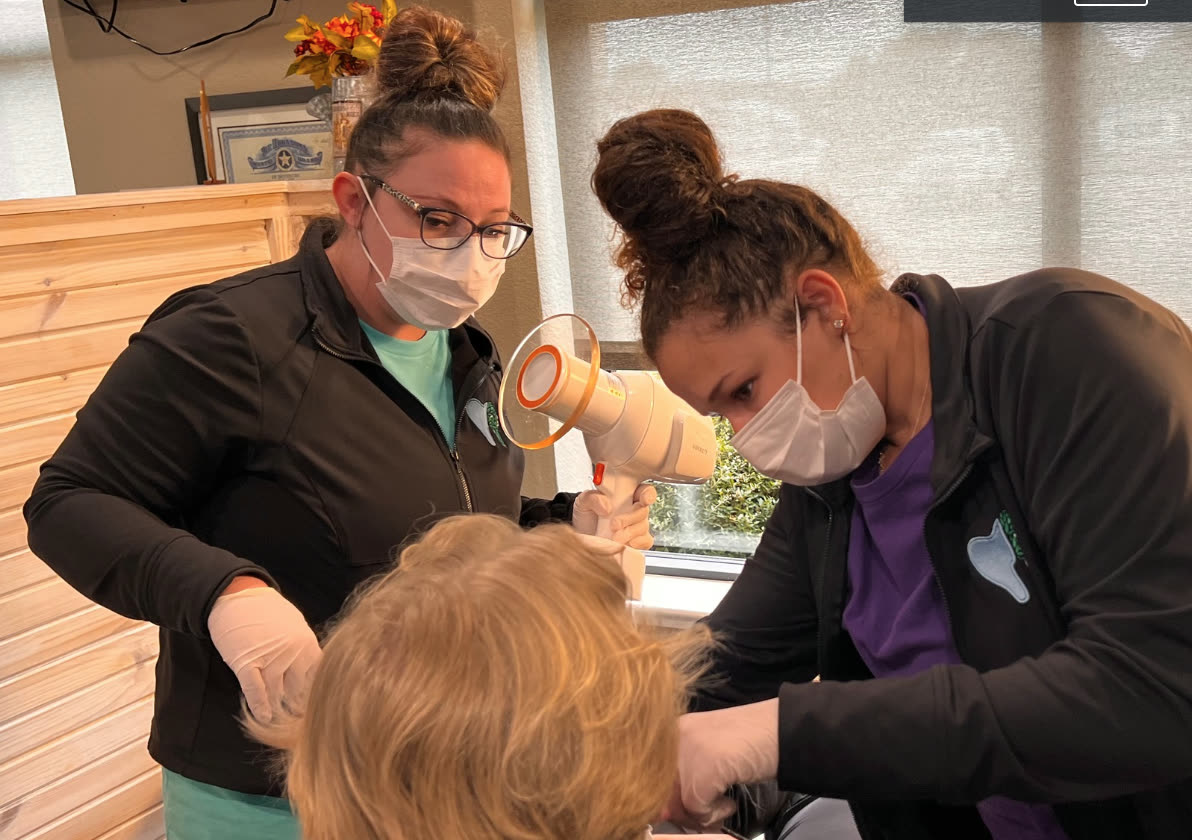 Assistants using an intraoral camera with a patient